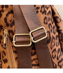Détail d'un sac à dos léopard avec boucles métalliques dorées et bretelles en nylon brun