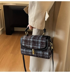 Détail du sac à bandoulière en tweed à carreaux avec garniture en cuir noir et fermoir