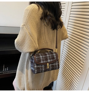Détail du sac bandoulière en tweed avec bordure en cuir et boucle dorée porté par mannequin