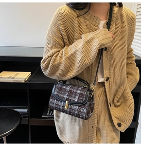 Détail d'un sac bandoulière vintage en tweed avec garniture en cuir et fermoir doré