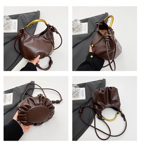 Deep brown leather bag detail showing golden handle, drawstring closure and pleated bottom