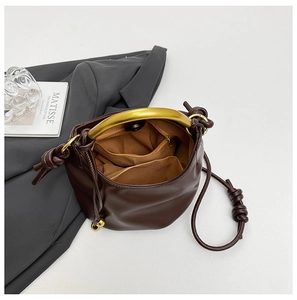 Detailed interior of dark brown cloud bag with gold handle and fabric pockets