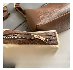 Detail of light gold zipper and premium leather texture on stylish crossbody bag