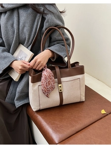Detail of canvas tote bag with leather trim and silk scarf on a luxury bench