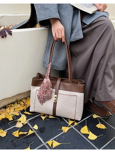Chic canvas tote bag with brown leather trim and silk scarf detail in an autumn setting