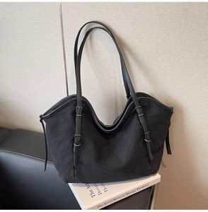 Detail of adjustable gunmetal buckle on minimalist large capacity black tote shoulder bag