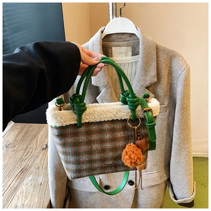 Detail of wool plaid handbag with faux fur trim and colorful decorative charms