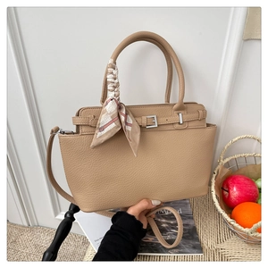 Detail of apricot pebbled leather tote bag with silk scarf and silver buckle strap