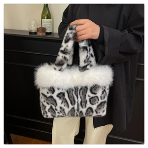 Détail du sac à main en peluche léopard avec bordure en fourrure blanche et deux anses