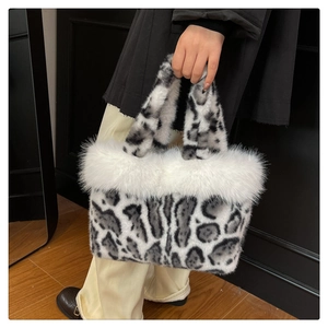 Détail du sac à main en peluche léopard avec bordure en fausse fourrure blanche et poignée