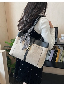 Detail of color-block canvas tote bag with leather trim and decorative silk scarf