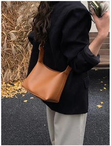 Brown litchi texture crossbody bucket bag styled with a professional autumn outfit