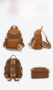 Brauner Damenrucksack aus Kunstleder mit geometrischem Gurt und weichem Bommelanhänger