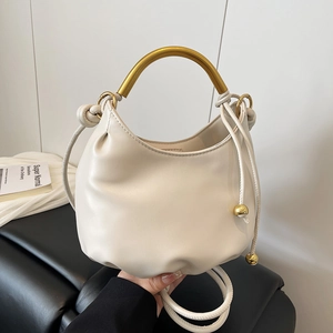 Creamy white leather cloud bag with gold metal handle and adjustable shoulder strap