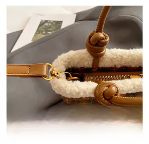 Detail of premium gold-tone swivel hook and faux shearling trim on plaid tote bag