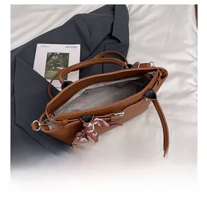 Top view of spacious brown lychee leather tote with printed silk scarf and inner pockets