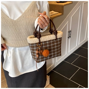 Detail of wool plaid handbag with fuzzy faux shearling trim and brown twisted handle