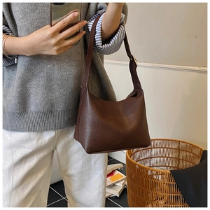 Detail of dark brown lychee grain leather hobo bag showing texture and wide strap