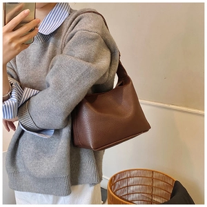 Detailed texture of dark brown pebbled leather shoulder bag with matching strap