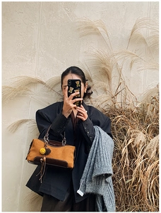 Sac à main chic en daim avec breloque et blazer noir pour un style automnal