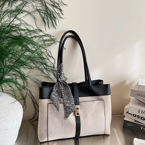 Canvas tote bag with black leather trim, gold lock and decorative silk scarf detail