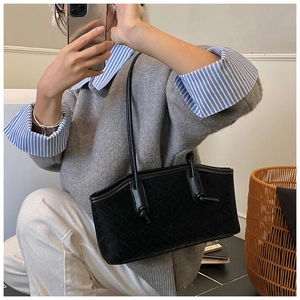 Détail du sac à bandoulière en cuir tressé noir avec un design de poignée nouée