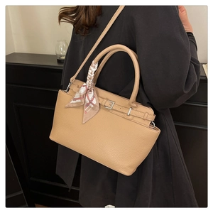 Detail of light khaki lychee grain leather handbag with decorative printed silk scarf wrap