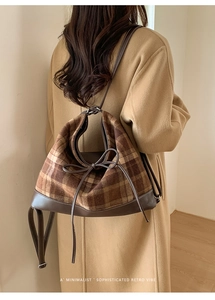 Close-up of retro plaid stitching tote bag with drawstring bow detail on a camel coat