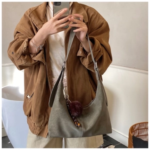 Close-up of a vintage dark grey suede hobo bag with a plush faux fur charm detail