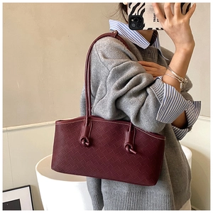 Détail d'un sac cabas tissé bordeaux avec bandoulière nouée lors d'un selfie