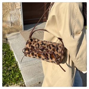 Detail of leopard print faux fur bag with brown leather bow and crossbody strap