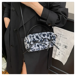 Detail of leopard print plush bag featuring black bows and stylish crossbody strap