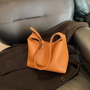 Brown litchi grain minimalist hobo bag with wide shoulder strap on black suit