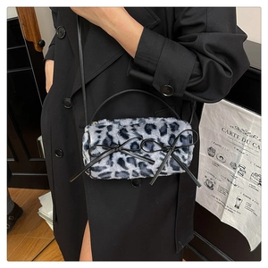 Detail of blue leopard plush cylinder bag with black bows and fluffy faux fur texture