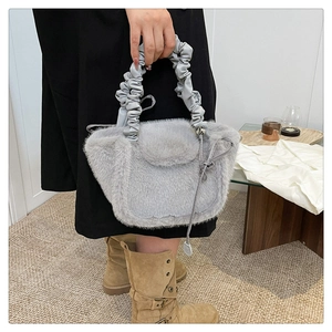 Detail of grey plush faux fur handbag with ruffled handle and soft texture for autumn