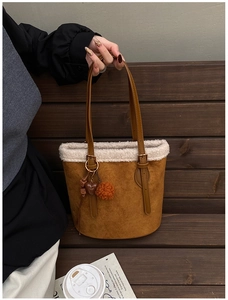 Detail of a brown suede tote with white faux fur trim and cute heart charms