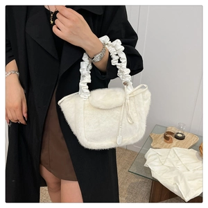 Detail of white faux fur handbag featuring soft plush texture and ruched silk handle