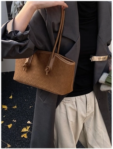 Gros plan sur le sac cabas en cuir tressé marron avec motif Intrecciato et nœud décoratif