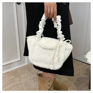 Detail of soft white faux fur handbag with a stylish ruched leather handle and side ties
