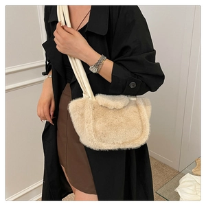 Detail of plush beige shoulder bag showing the fluffy texture and soft strap on a model