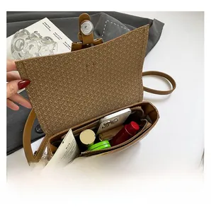 Vue intérieure du sac en cuir marron montrant sa capacité pour téléphone et maquillage