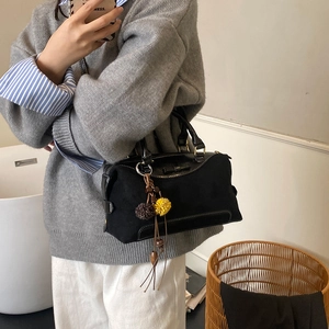 Photo lifestyle d'un sac à main boston noir avec pompon et doubles poignées