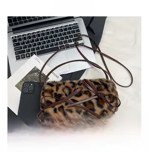 Detail view of leopard print plush bag featuring sweet brown leather bow accents and strap