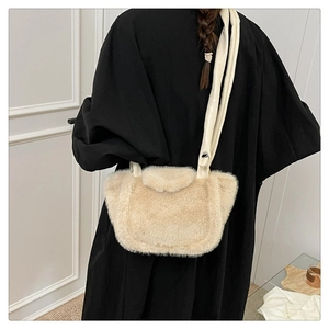 Detail of plush beige shoulder bag showing soft faux fur texture and leather strap