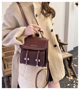 Detail eines vintage dunkelbraunen Lederrucksacks mit Logo und Kontrastnähten für Damen