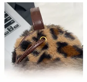 Macro shot showing leopard faux fur texture, leather handles and gold metal eyelets