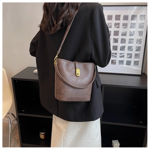 Détail du sac seau marron vintage avec fermoir doré et cuir PU à texture naturelle