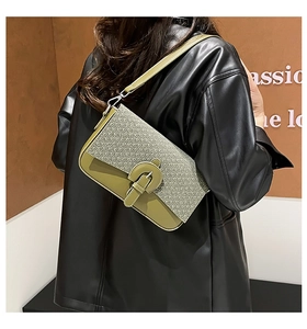 Détail du sac sous l'aisselle rétro avec texture tissée et cuir vert lisse