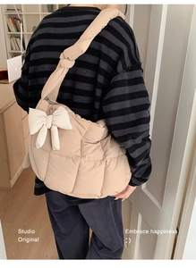 Détail du sac bandoulière matelassé beige avec grand nœud blanc et bandoulière rembourrée
