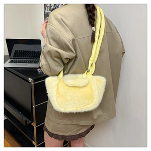 Detailed side view of the bright yellow plush hobo bag with a padded shoulder strap